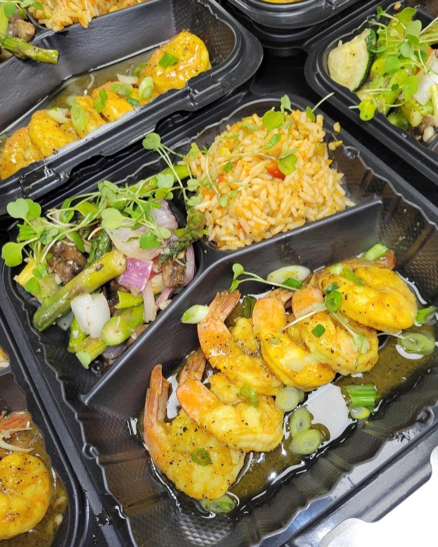 Boxed meal with sauteed shrimp, seasoned rice and roasted asparagus