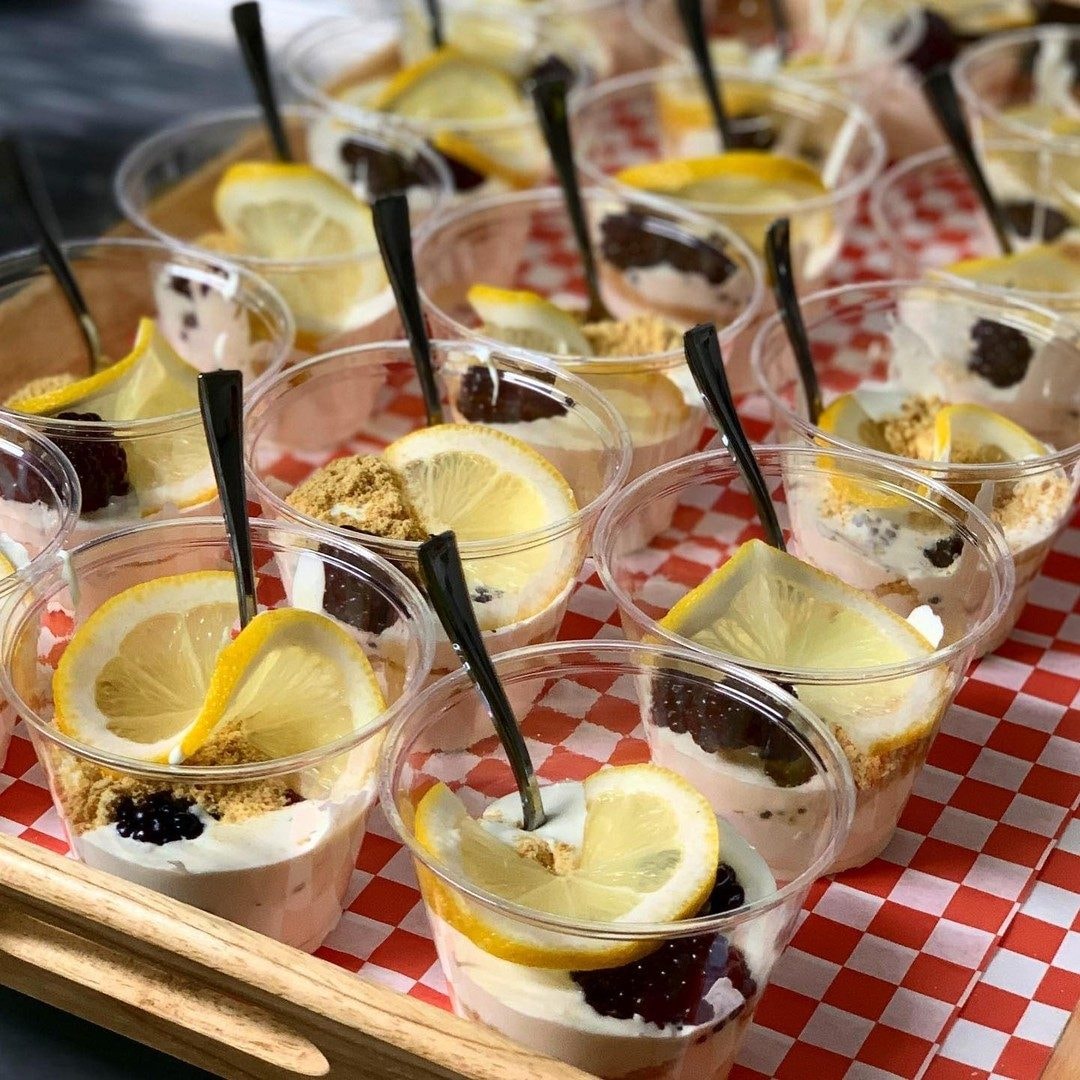 Individual lemon blackberry cheesecake dessert cups with graham crumble and lemon slices