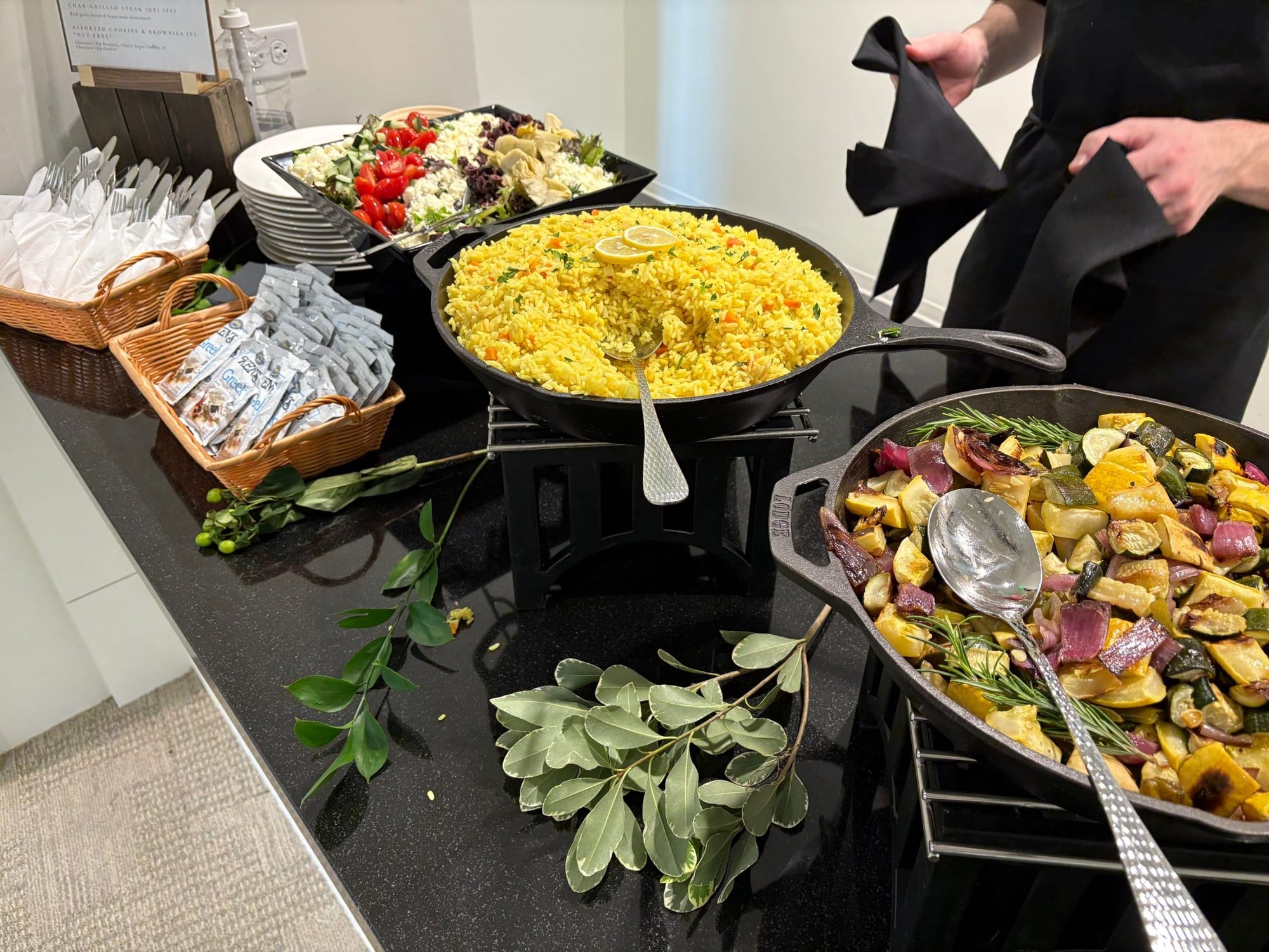 Saffron rice and roasted squash and red onion served in cast iron skillets with a Greek salad