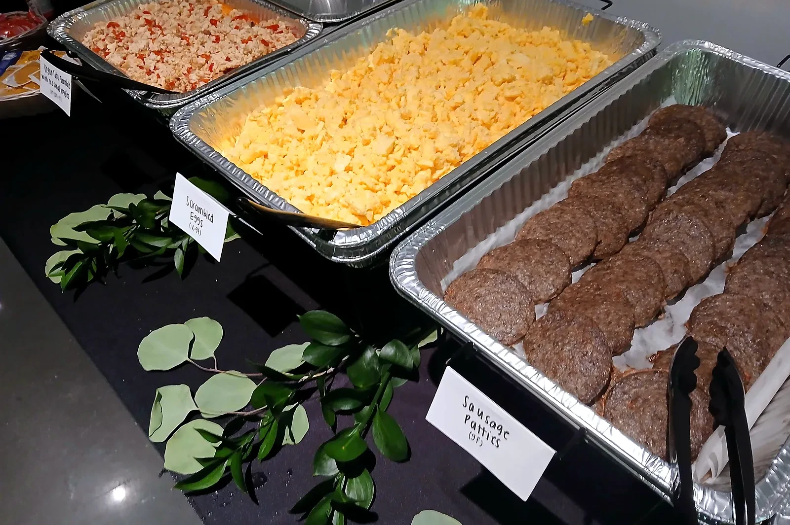 Breakfast line with scrambled eggs, sausage links and seasoned tofu for a production crew