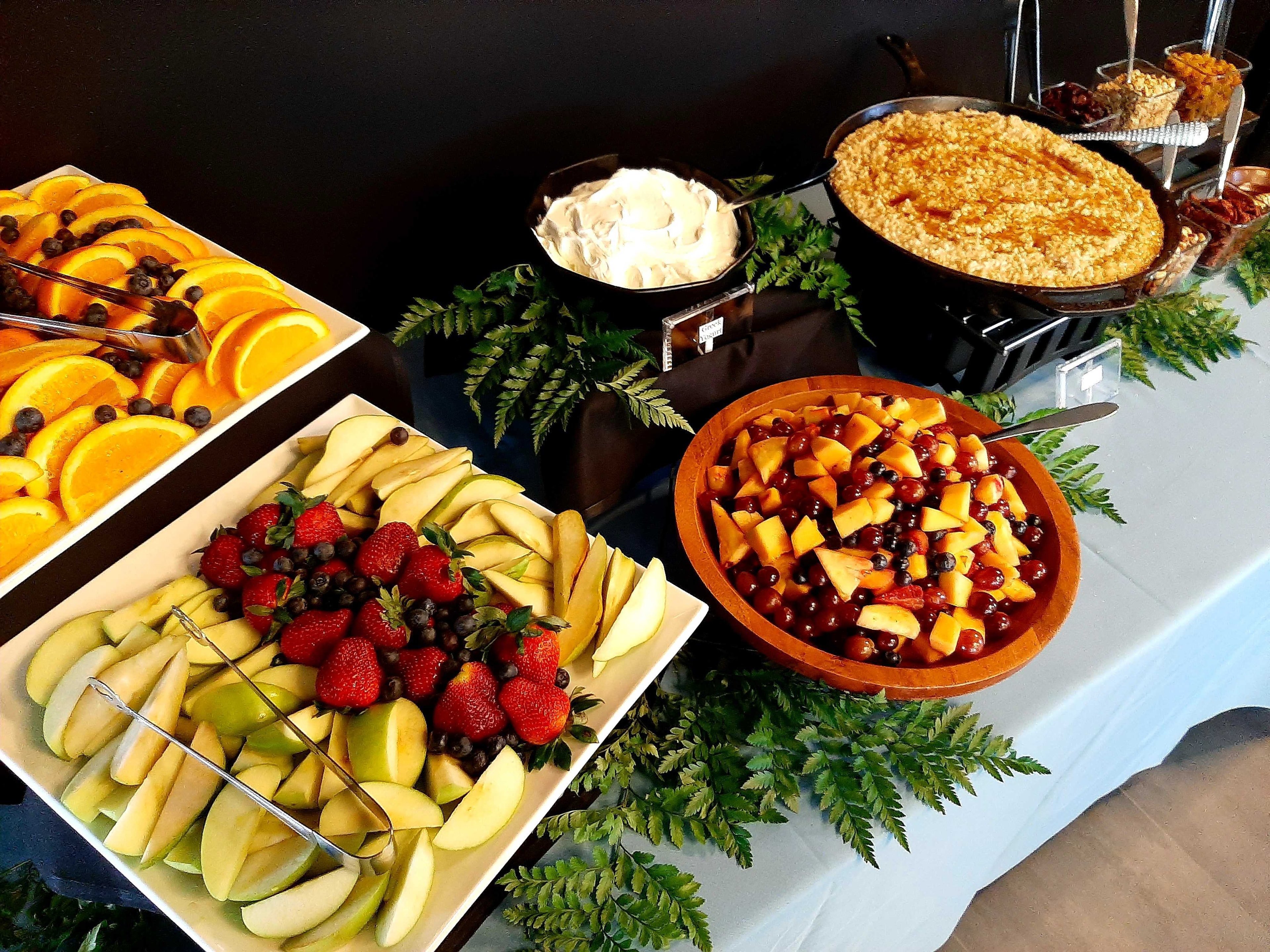 Atlanta production catering breakfast spread with oatmeal bar, sliced fruit, and fern greenery