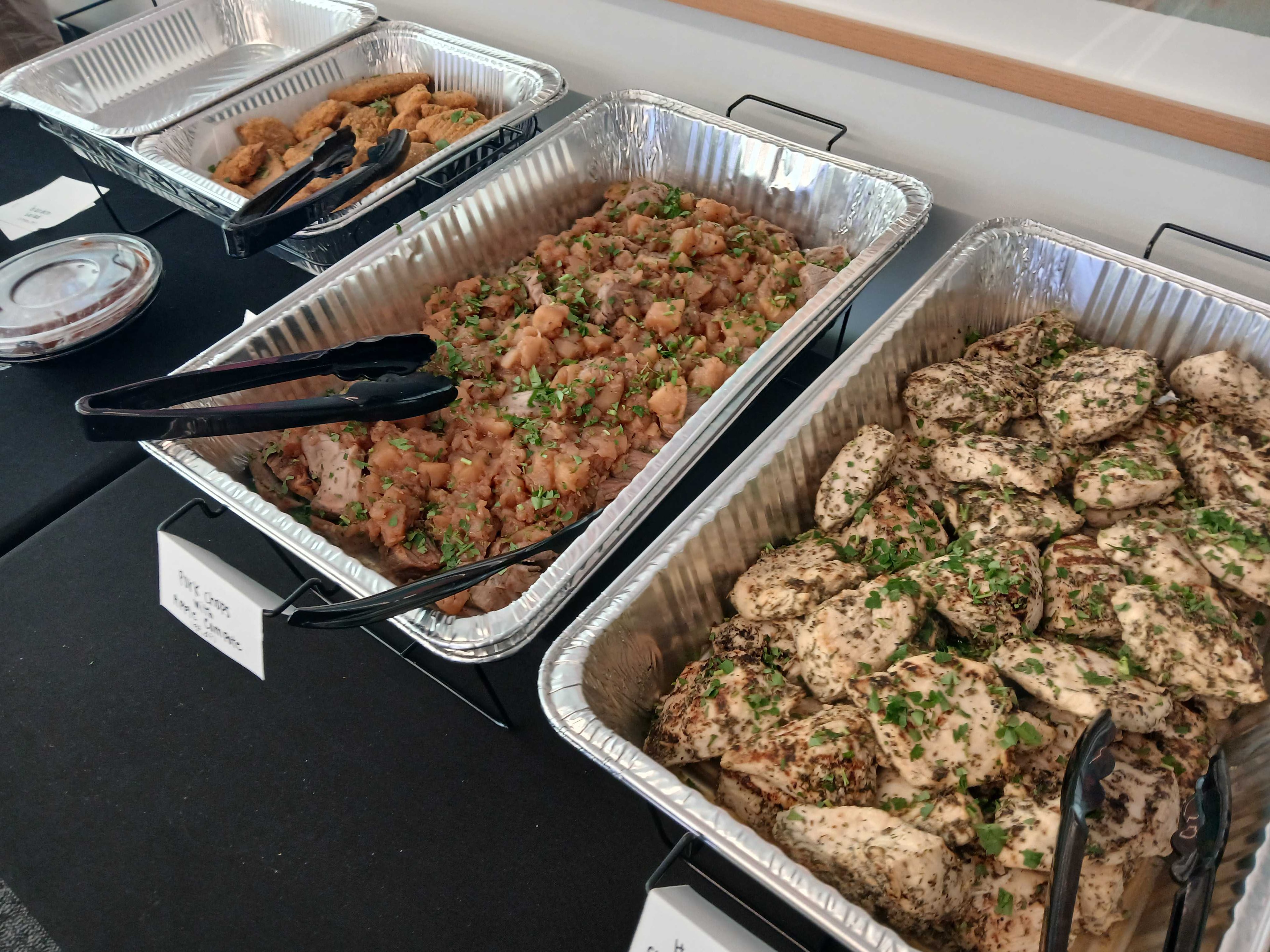 Individually plated pork chops with apple jam sauce and herb chicken tenders — Atlanta production catering boxed meal
