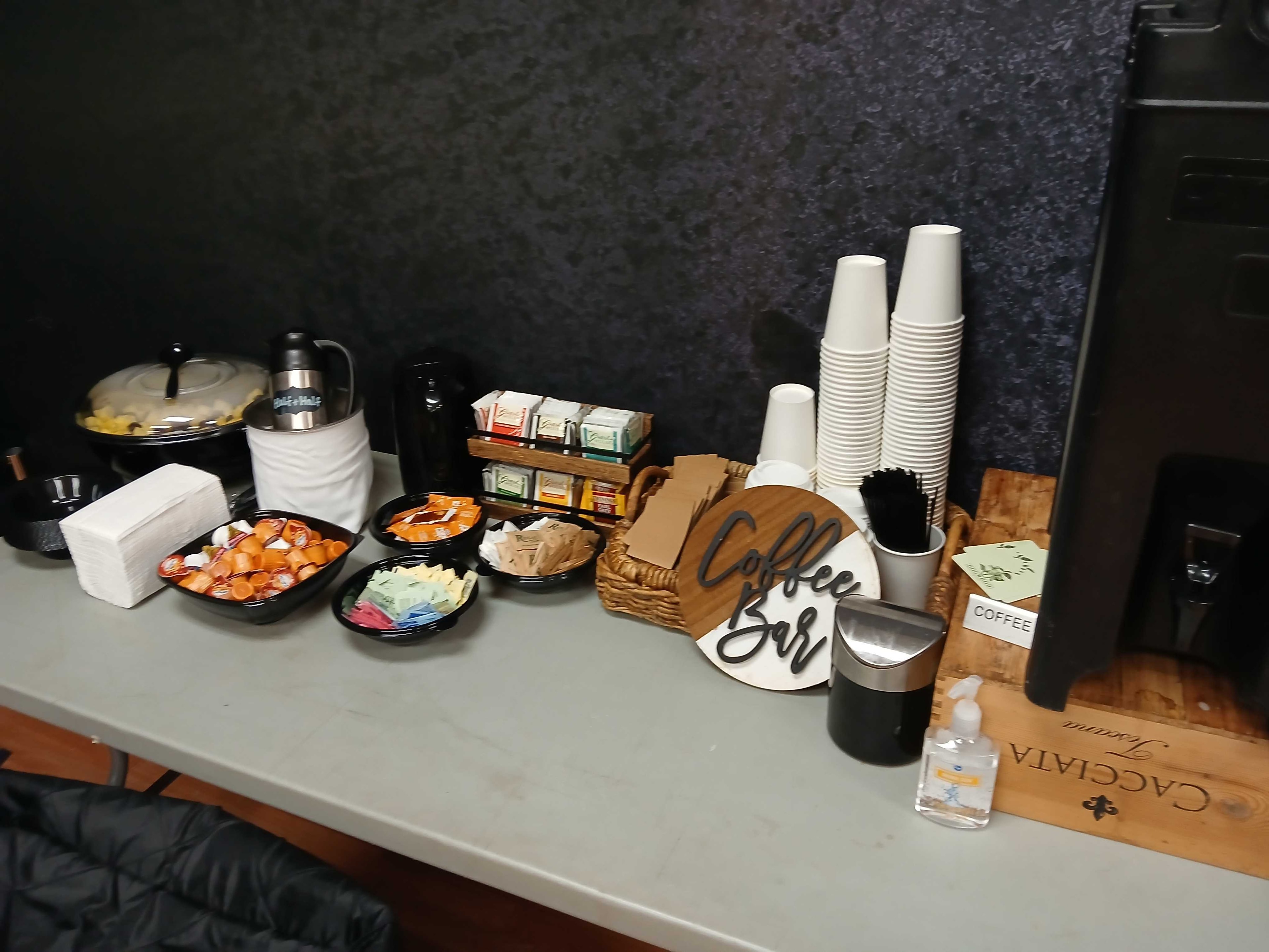 Full craft service coffee bar with K-cups, tea selections, cups, and stirrers on an Atlanta film production set